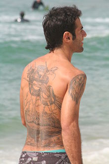 220px-Man_with_tattoo_on_his_back_-_at_the_beach
